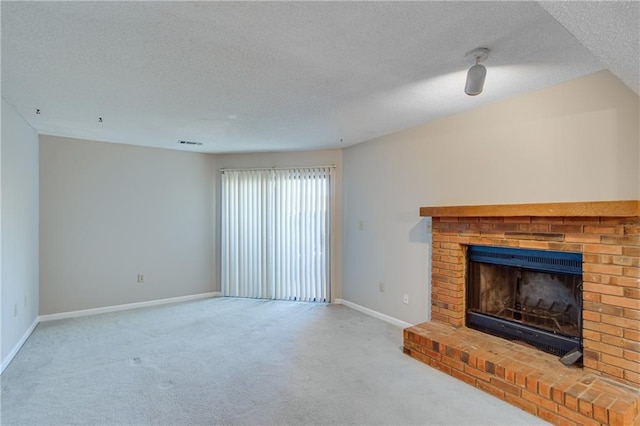 unfurnished living room featuring a fireplace, a textured ceiling, and carpet flooring