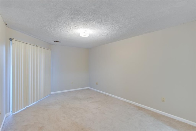 carpeted spare room with a textured ceiling