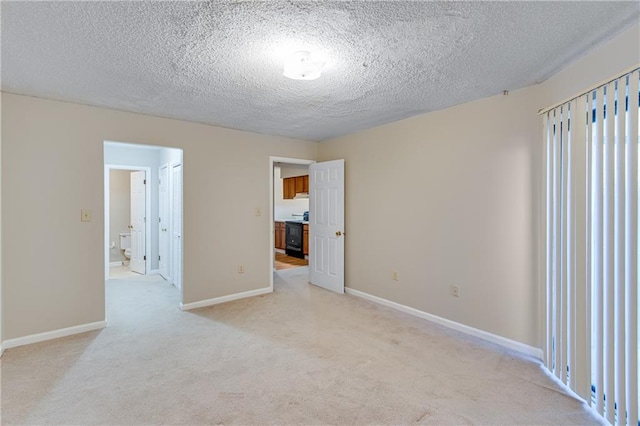 empty room featuring light colored carpet and a textured ceiling