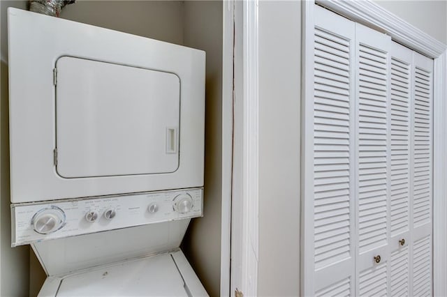 clothes washing area with stacked washer and clothes dryer