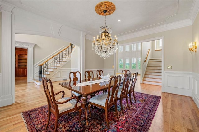 4720 Cliffside Ct, Marietta, GA 30067 - dining area featuring a chandelier, stairs, a decorative wall, light wood-style floors, and crown molding