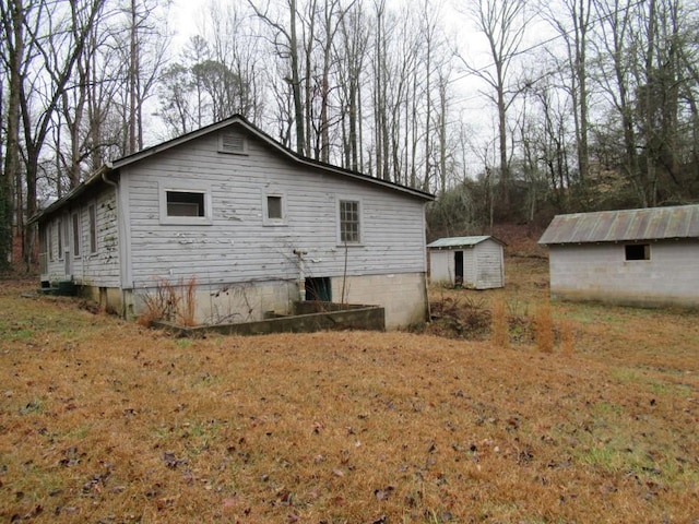 view of home's exterior with a yard and a storage shed