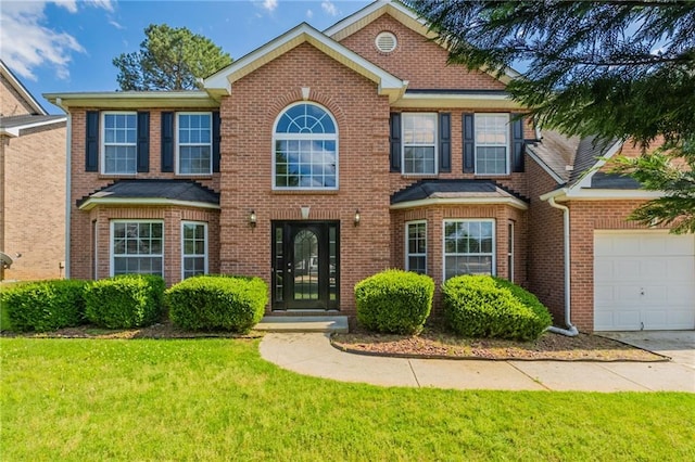 view of front of home with an attached garage, a front lawn, concrete driveway, and brick siding