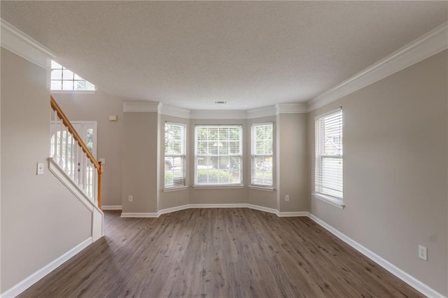 unfurnished living room featuring wood finished floors, a textured ceiling, crown molding, stairway, and baseboards