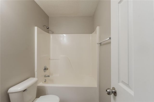 full bathroom featuring toilet, a textured ceiling, and shower / tub combination