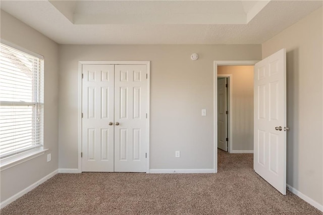 unfurnished bedroom with carpet floors, a closet, and baseboards