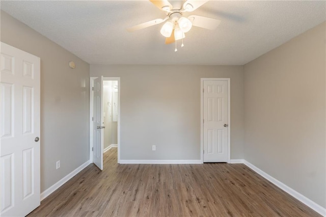 unfurnished bedroom with wood finished floors, baseboards, a ceiling fan, and a textured ceiling