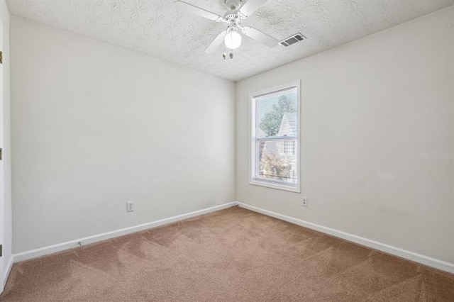 unfurnished room with carpet flooring, ceiling fan, and a textured ceiling