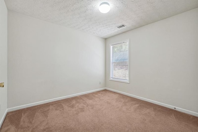 carpeted spare room featuring a textured ceiling