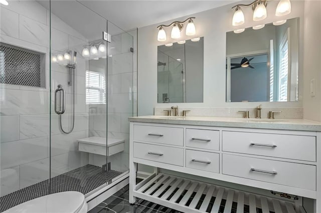 bathroom featuring ceiling fan, a shower with door, vanity, and a healthy amount of sunlight