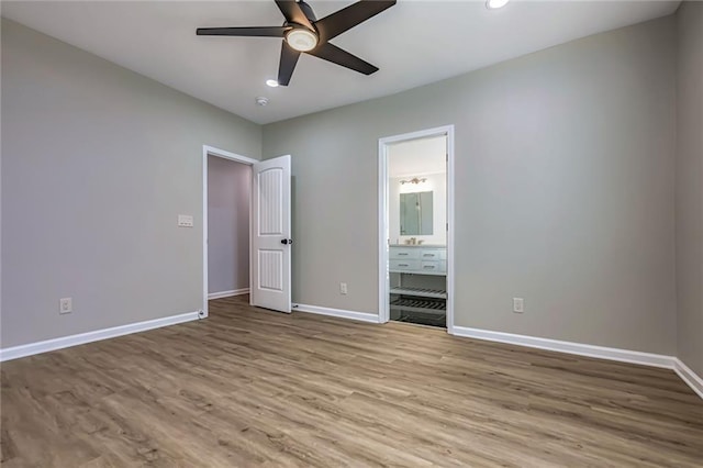 unfurnished bedroom with connected bathroom, ceiling fan, and light wood-type flooring