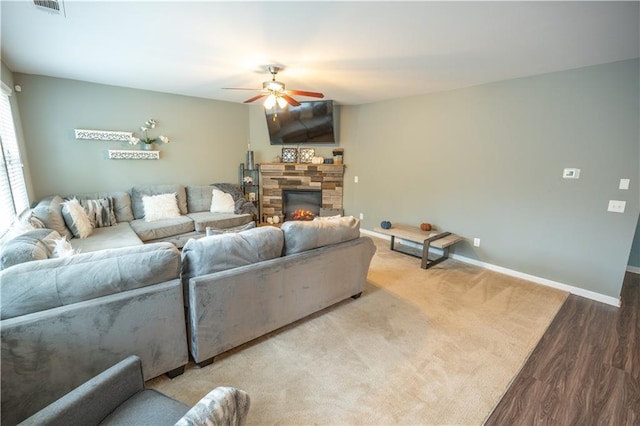 living room with a fireplace, ceiling fan, and hardwood / wood-style flooring