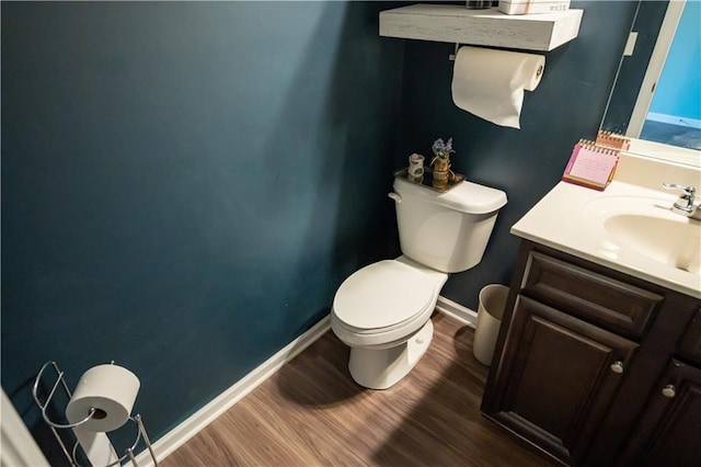 bathroom featuring toilet, hardwood / wood-style flooring, and vanity