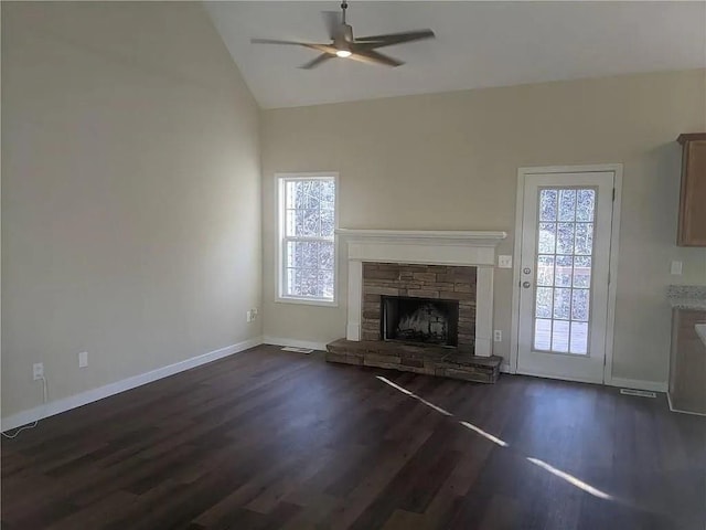 unfurnished living room featuring vaulted ceiling, ceiling fan, dark hardwood / wood-style floors, and a fireplace