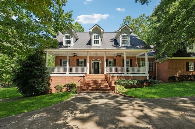 cape cod house with a front yard, ceiling fan, and a porch