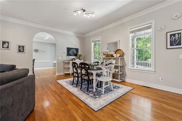 dining space featuring hardwood / wood-style floors and ornamental molding