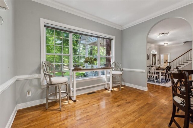 living area featuring hardwood / wood-style flooring and ornamental molding