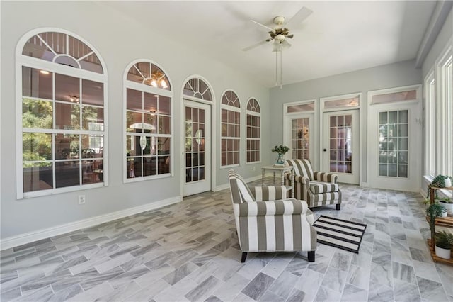 unfurnished sunroom featuring ceiling fan