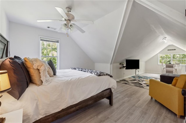 bedroom with multiple windows, light hardwood / wood-style floors, ceiling fan, and lofted ceiling