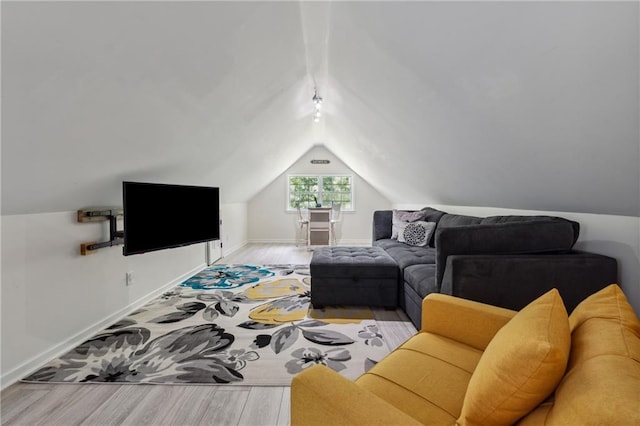 living room featuring lofted ceiling and light hardwood / wood-style flooring