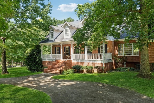 cape cod home featuring a front yard and covered porch