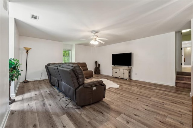 living room featuring ceiling fan and light hardwood / wood-style floors