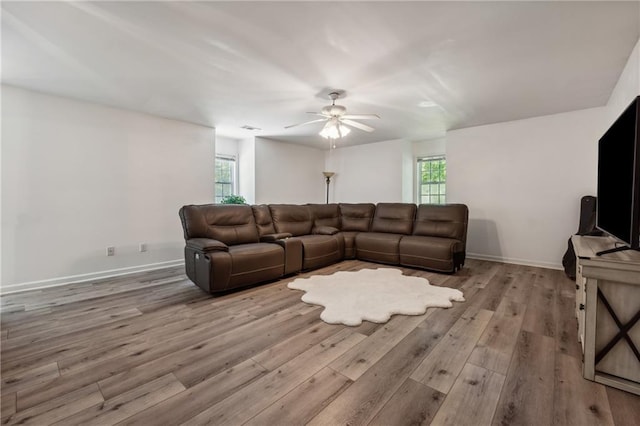 living room featuring ceiling fan, a healthy amount of sunlight, and light wood-type flooring