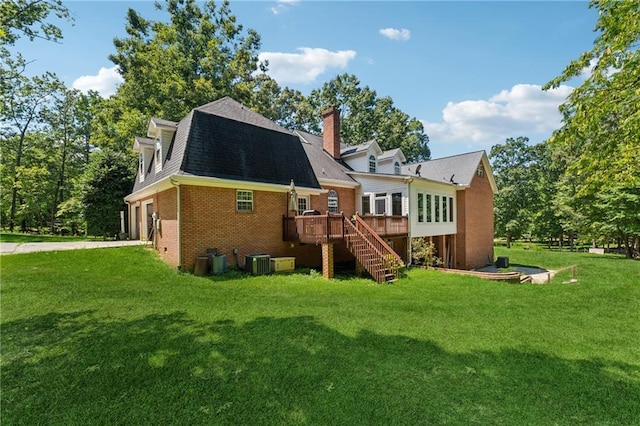 rear view of house featuring a wooden deck, a lawn, and central air condition unit