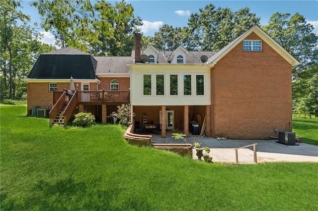 back of property with a wooden deck, a yard, central AC unit, and a patio