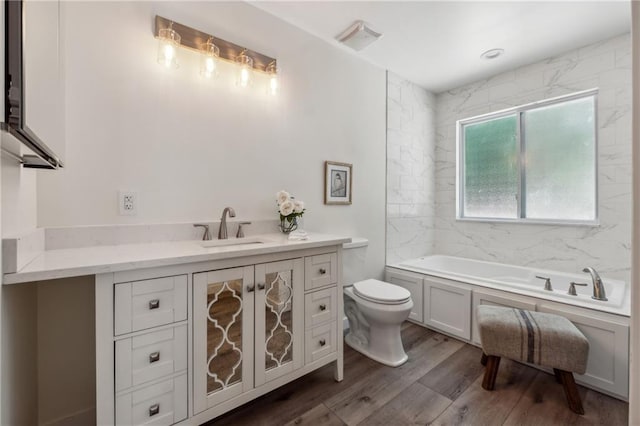 bathroom featuring vanity, wood-type flooring, a tub, and toilet