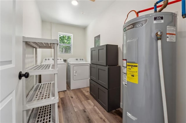 laundry room featuring water heater, separate washer and dryer, and light hardwood / wood-style flooring