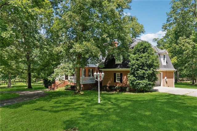 view of property hidden behind natural elements featuring a garage and a front lawn