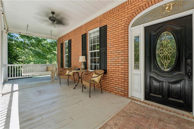 doorway to property featuring ceiling fan and a porch