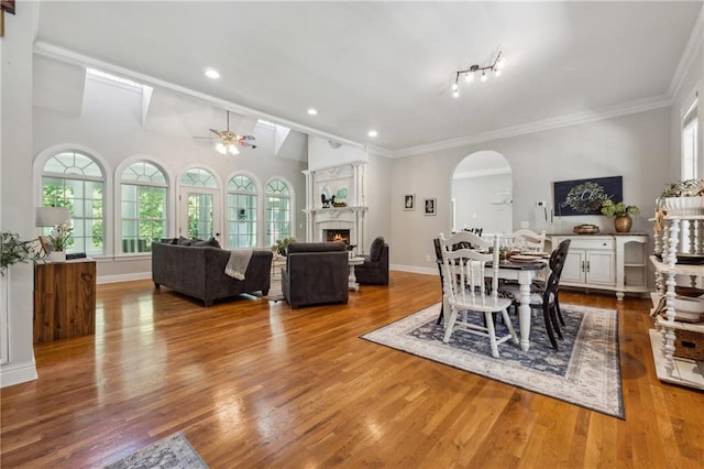 dining space featuring hardwood / wood-style flooring, ceiling fan, lofted ceiling, and crown molding