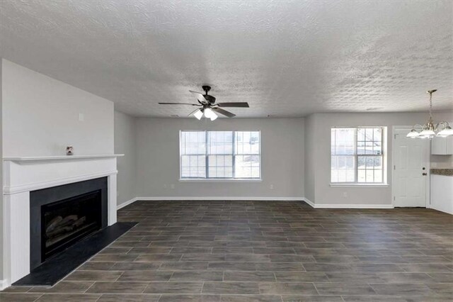 508 Cascade Walk, Mcdonough, GA 30253 - unfurnished living room with ceiling fan with notable chandelier, a textured ceiling, and a healthy amount of sunlight