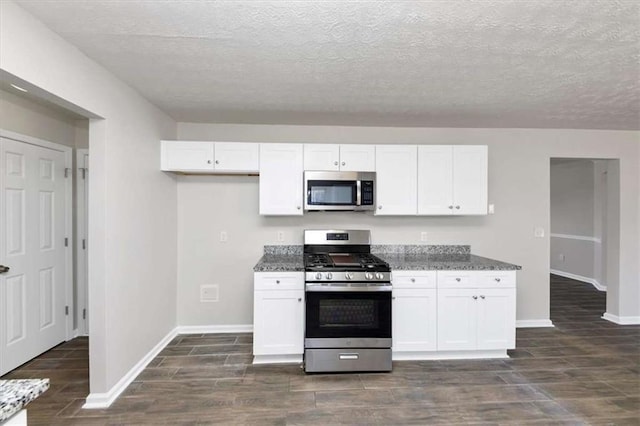 508 Cascade Walk, Mcdonough, GA 30253 - kitchen featuring a textured ceiling, white cabinetry, dark stone countertops, and stainless steel appliances