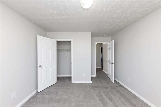 508 Cascade Walk, Mcdonough, GA 30253 - unfurnished bedroom with a textured ceiling, a closet, and light carpet