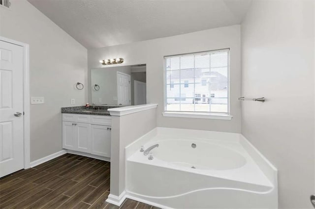508 Cascade Walk, Mcdonough, GA 30253 - bathroom with a tub, lofted ceiling, and vanity