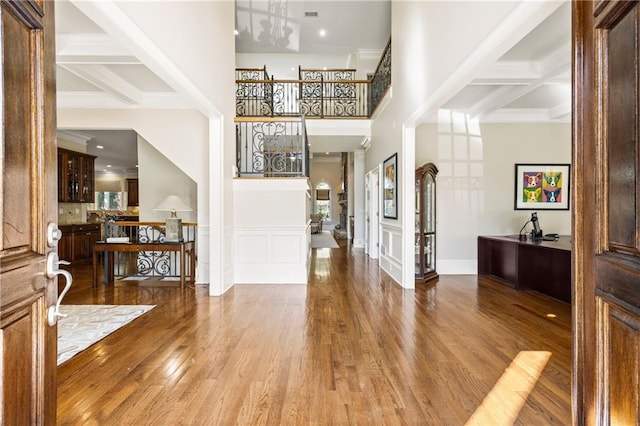 foyer entrance featuring coffered ceiling, wood-type flooring, and beam ceiling