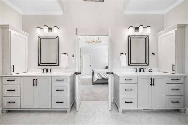 full bath with marble finish floor, crown molding, and a sink