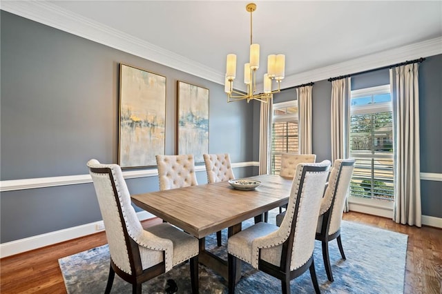 dining space featuring ornamental molding, wood finished floors, baseboards, and a chandelier