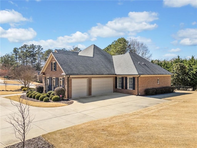 traditional-style house featuring driveway, a front lawn, an attached garage, a shingled roof, and brick siding