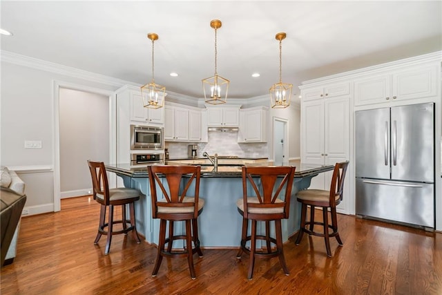 kitchen with dark countertops, white cabinetry, appliances with stainless steel finishes, decorative backsplash, and dark wood-style flooring