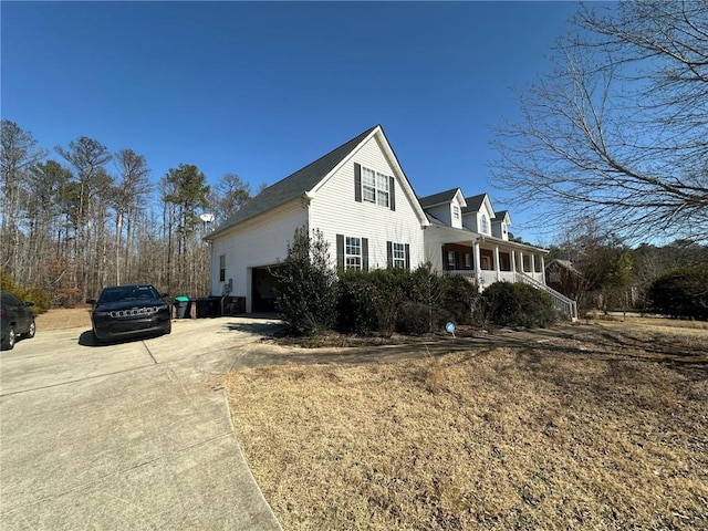 view of home's exterior with a garage and covered porch