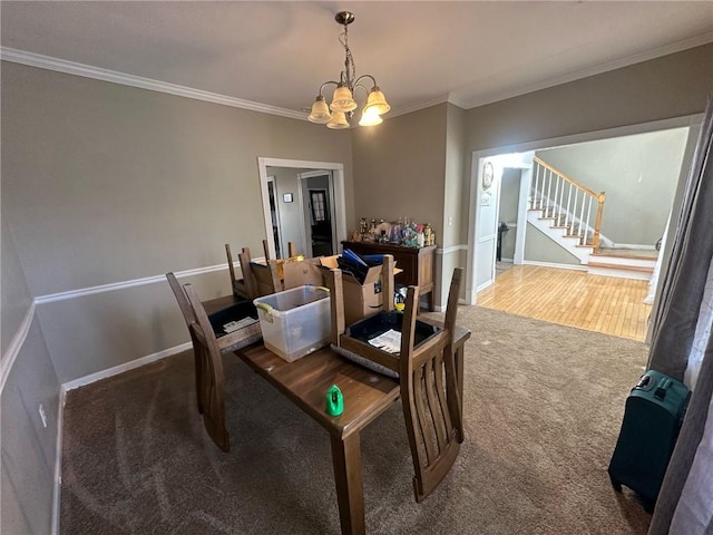 dining room with ornamental molding, carpet, and a chandelier