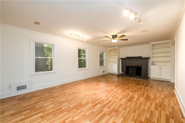 4324 Japonica Ct SW, Lilburn, GA 30047 - unfurnished living room with rail lighting, a fireplace with raised hearth, ceiling fan, light wood finished floors, and ornamental molding