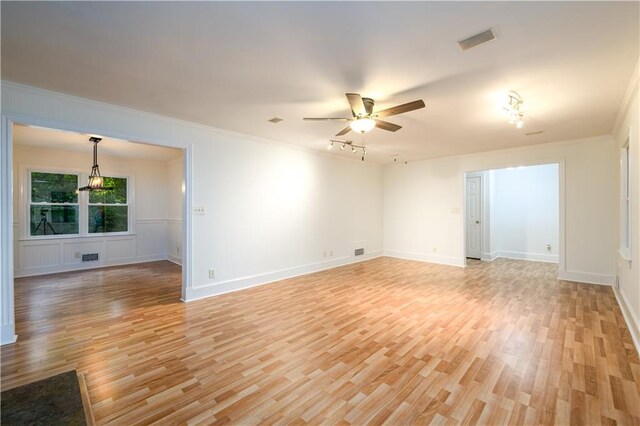 4324 Japonica Ct SW, Lilburn, GA 30047 - empty room with ornamental molding, a chandelier, light wood-style floors, wainscoting, and a decorative wall