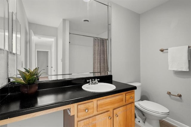 bathroom with vanity, toilet, and curtained shower