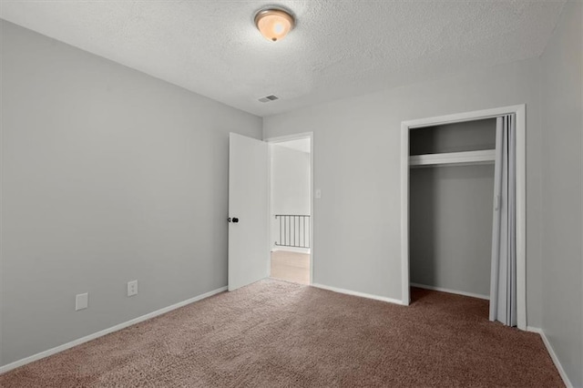 unfurnished bedroom with a closet, a textured ceiling, and carpet