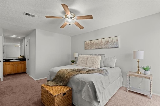 bedroom featuring ceiling fan, sink, light carpet, and a textured ceiling